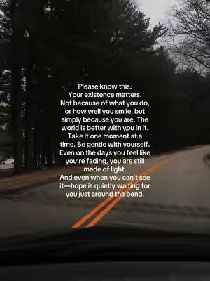 A scenic shot of a road winding through a forest, likely taken from a car. The colors are muted, with a dark green from the trees on either side and a gray sky overhead. The road has a yellow dividing line. Text is overlaid on the image containing a motivational message.