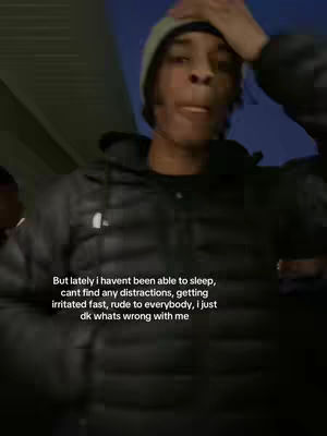 A young man in a beanie and black jacket appears slightly distressed, touching his head. Text overlays at the bottom share his struggles.