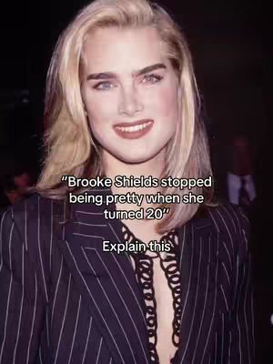 A headshot of Brooke Shields. She has pale skin, blonde hair, and is wearing a striped blazer. Text overlay is in the center.