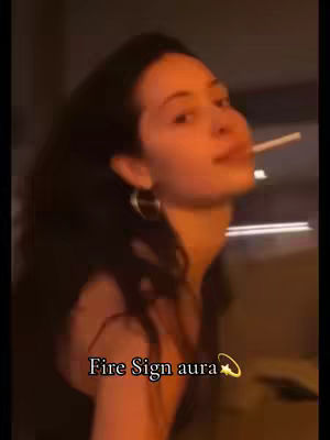 A woman with dark hair and hoop earrings is seen in a dimly lit setting. She has a cigarette in her mouth and is looking up, with the text overlayed at the bottom.