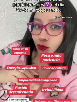 A woman with dark hair and pink-framed glasses is centered in the frame.  She is wearing red lipstick and a pink pajama-style top.  Text overlays in colored boxes describe astrological effects.