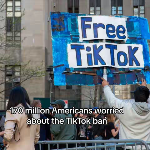 A crowd of people are seen outdoors, with a street and buildings in the background. A large sign that reads "Free TikTok" is being held up by several people in the crowd. A person, seen from the back, is holding the sign. Text overlayed on the image states "170 million Americans worried about the TikTok ban".
