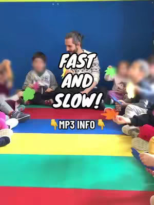 The image shows a group of children and an adult in a classroom setting. They are sitting on colorful mats. The text overlay, “FAST AND SLOW!”, is placed in the center with additional smaller text, “MP3 INFO”. The setting appears to be a music or activity session, as the children and adult appear to be interacting with leaf-shaped props.