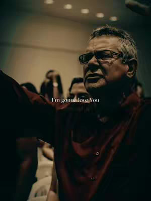The cover image shows an older man with glasses holding up one arm, presumably in a worship setting. He is wearing a red shirt and has a serious expression. The text overlay reads 'I'm gonna love You'. Other figures are blurred in the background.