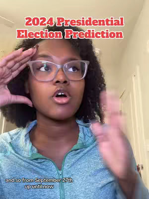 A young Black woman with curly hair and glasses is the main focus. She is looking directly at the camera with a surprised expression, with her hands up on the sides of her face, partially blocking her forehead. The upper part of the screen includes red text, overlaid on top of the image.