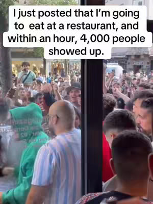 The cover image shows a large crowd of people gathered outside a building, likely a restaurant. A text overlay states that 4,000 people showed up within an hour of a post about eating at the restaurant. The composition is bustling, with a mix of people in the foreground and background, suggesting a significant event or viral moment. The color palette appears natural, with the setting sun illuminating the crowd.