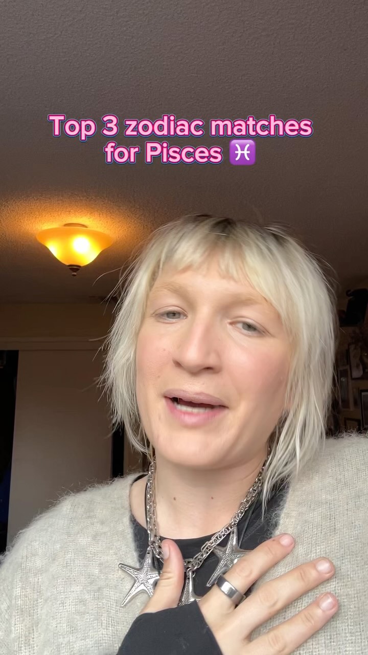 A woman with short blonde hair, wearing a silver necklace with star-shaped pendants, is positioned in front of a blurred background with a warm-toned ceiling light. The overlay text announces 'Top 3 zodiac matches for Pisces'.