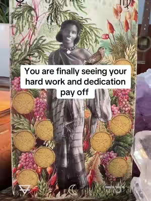 The cover image features a tarot card illustration. A woman with dark skin and hair is the central figure, dressed in draped clothing. She is holding a small bird on her shoulder. Surrounding her are floral and plant elements, along with golden coins. A white rectangle overlay contains the text, 'You are finally seeing your hard work and dedication pay off'. The overall composition is colorful and detailed.