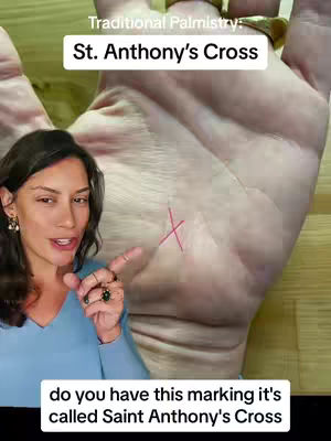 The cover image features a woman in a light blue top, pointing. To the right of the woman is a large hand with palmistry marks. Above the hand is white text that says: Traditional Palmistry: St. Anthony's Cross. Below, another text says: do you have this marking it's called Saint Anthony's Cross
