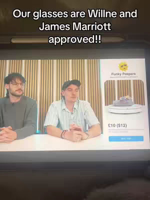 Two men are seated at a white table with a screen in front of them. The screen displays a promotional image for "Funky Peepers" featuring a product on a rotating platform. Text overlays at the top of the image indicate the glasses shown are "Willne and James Marriott approved!"