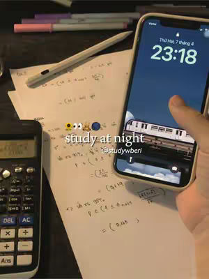 The cover image shows a close-up view of a workspace. On the left is a calculator and a sheet of paper covered in mathematical equations and handwritten notes. To the right, an iPhone displays a train traveling along a railroad track during the day. Several pens and markers are visible in the upper half of the image. The composition is centered around studying.