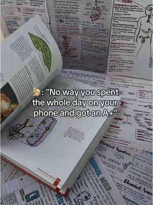 The image shows a collection of textbooks and handwritten notes, along with a main textbook open to a page with a large diagram. A text overlay appears in the bottom center, quoting a statement with an emoji of a person's face.