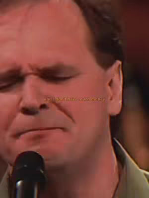 The cover image shows a close-up of a man's face. He is positioned slightly off-center, with the right side of his face more visible. He is holding a microphone close to him. The background is dark, suggesting a stage or performance setting. The man appears to be singing or speaking. His expression is serious, with his eyes closed or nearly closed, and a slight downturn of his mouth.