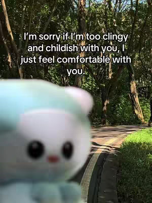 An image featuring a blurred plushie in the foreground, a path with trees on either side in the middle ground and a message overlayed on the background.
