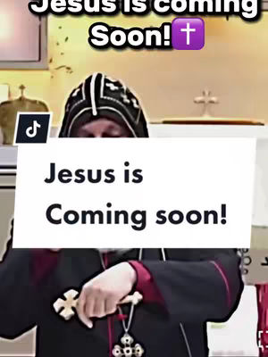 The image features a religious figure, likely a priest, holding a cross and wearing religious attire. A white banner across the foreground displays the text 'Jesus is Coming Soon!' above the figure, with a purple cross icon next to the text. The background suggests a church interior with a cross visible. The overall color scheme is muted with red prominent in the vestment