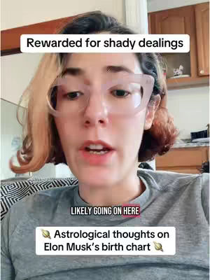 A woman with fair skin and short, layered hair in shades of blonde and brown is looking directly at the camera. She wears large, clear-framed glasses. Above her head, a white rectangular text box reads 'Rewarded for shady dealings'. Below her, a smaller white box reads 'LIKELY GOING ON HERE' and another below this says 'Astrological thoughts on Elon Musk's birth chart'. The background appears to be the interior of a home, with hints of a kitchen visible.
