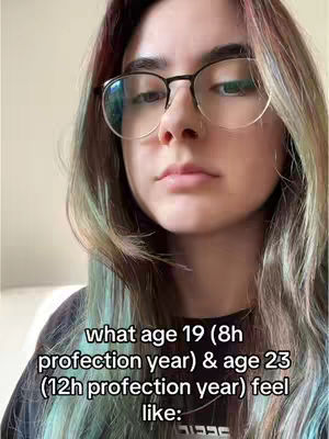 A selfie-style image featuring a person with long, multi-toned hair, wearing glasses with a black frame. The person is looking directly at the camera with a neutral expression. Text overlay is displayed at the bottom of the image, written in white. The background is softly blurred.