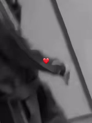 Monochrome shot with a blurred person, possibly reaching out. Overlayed with a single red heart icon.