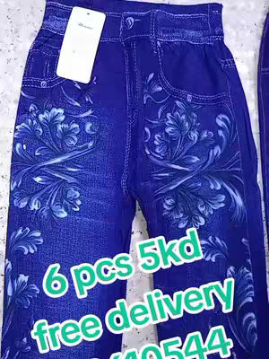 The image showcases a close-up of a pair of blue denim leggings with a floral pattern. The leggings, appearing to be new, boast a high waist and are adorned with decorative floral patterns across the front. Overlayed text in a rounded green font advertises the product, with pricing and contact information.