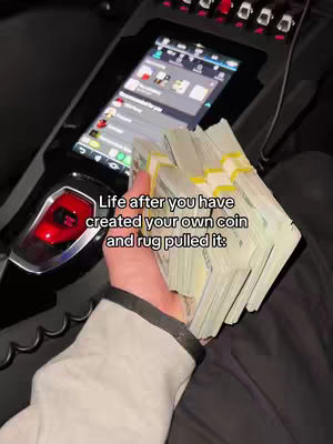 The cover image shows a person's hand holding bundles of US dollar bills inside a car, with a digital display in the background. Text overlayed on the image reads 'Life after you have created your own coin and rug pulled it:'.