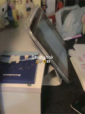 The cover image is a study setting. It shows an open book, a tablet propped up, a white table, and some items are beside the table. The lighting is natural. The overall composition has a simple and organized feel, suggesting a study environment.