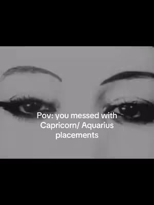 A grayscale close-up featuring two eyes with dark eyeliner, positioned centrally against a dark background. Text overlayed at the bottom states, "Pov: you messed with Capricorn/ Aquarius placements."