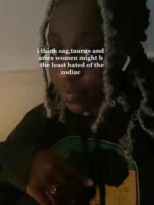A close-up shot featuring a person with braided hair, partially covering their face. Text overlayed in the center reads, "i think sag, taurus and aries women might b the least hated of the zodiac."