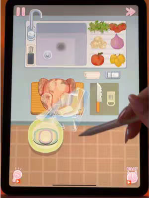 The cover image is a stylized depiction of a cooking simulation game interface on an iPad. The screen displays a kitchen countertop with various virtual elements. A clean, modern sink is visible in the top-left corner. Adjacent to the sink a platter of greens, tomatoes, cauliflower, onion, apple and yellow fruit. Below the vegetables, a wooden cutting board contains a cooked chicken. Behind the chicken are more UI elements like a knife and a phone-like object. An interactive plate with food on it lies below. The bottom right corner has a timer and a pink graphic. A stylus and a hand holding it are slightly visible indicating interaction on the screen.