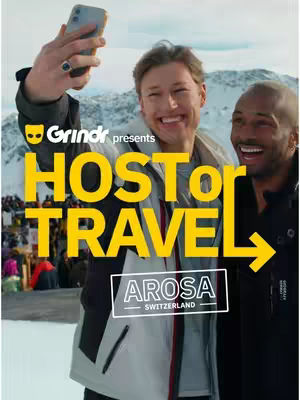 A cover image for the video shows two smiling men in a snowy outdoor setting, with one holding a phone up to take a selfie. The phrase "Grindr presents HOST OR TRAVEL" in large yellow letters. Underneath, a white rectangle displays "AROSA SWITZERLAND". The background is a blurred view of a snowy mountain landscape.