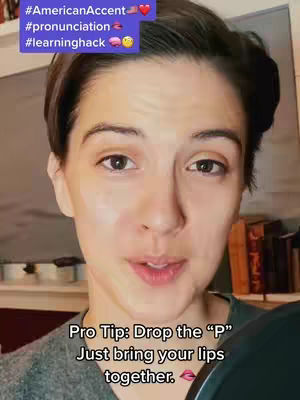 A close-up shot of a woman with short brown hair addressing the camera. Text overlays are present in the upper left corner, and more text overlays at the bottom.
