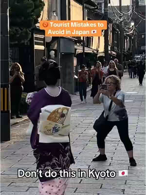 A street scene in Japan with a woman in traditional attire (kimono) walking away from the camera. In the foreground, a person is taking a photo of her. Other people are in the background. Overlaid text warns viewers about tourist behavior in Kyoto.