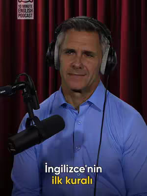 A man wearing headphones and a blue shirt is the central focus, set against a backdrop of deep red curtains. The image is framed with a podcast-style setup, including a microphone, suggesting a recording studio or personal broadcast environment. Text overlays at the top and bottom with a clear font.