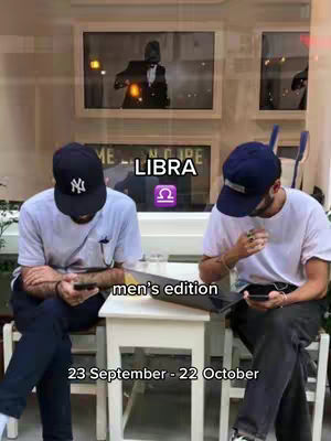 Two men are seated outdoors, one wearing a black cap and the other a blue cap. They are seated at a table with a laptop. Overlay text indicates the video's astrology theme.