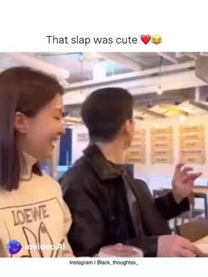 A woman is laughing while looking at another person, who seems to be a man. The man is facing away from the camera and has his arm raised. The text "That slap was cute" is at the top of the image.