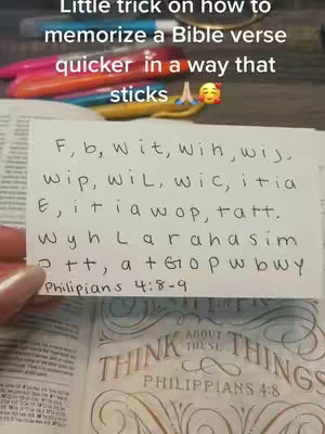 The cover image shows a person's hand holding a small white card with handwritten notes. The card is placed over an open Bible. The text overlay on top reads 'Little trick on how to memorize a Bible verse quicker in a way that sticks'. The background includes colorful pens and pencils.