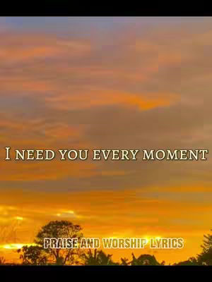 The image depicts a sunset with a vibrant sky of orange and yellow hues. Text overlays are present, with the phrase 'I NEED YOU EVERY MOMENT' at the center and 'PRAISE AND WORSHIP LYRICS' at the bottom. Silhouetted trees and foliage are visible at the bottom, adding a naturalistic element.