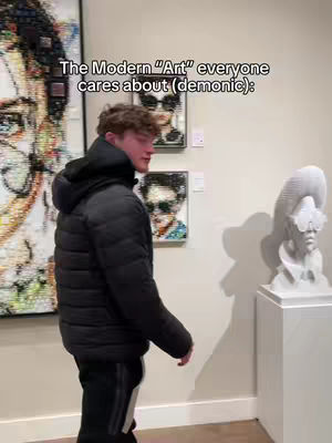 A man in a black puffer jacket walks through a modern art museum, the background includes art pieces and sculptures.