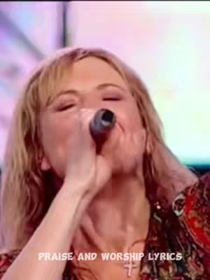 The image shows a woman with blonde hair, singing into a microphone. Her eyes are closed, and her mouth is open as she sings. The background is blurred. Below, white text reads 'PRAISE AND WORSHIP LYRICS'.