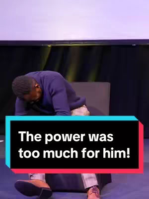A man, dressed in a dark blue sweater and tan pants, is slumped forward in a chair with his head resting on his arms. A text overlay in a colored box sits in front of the man's torso, with the text 'The power was too much for him!'