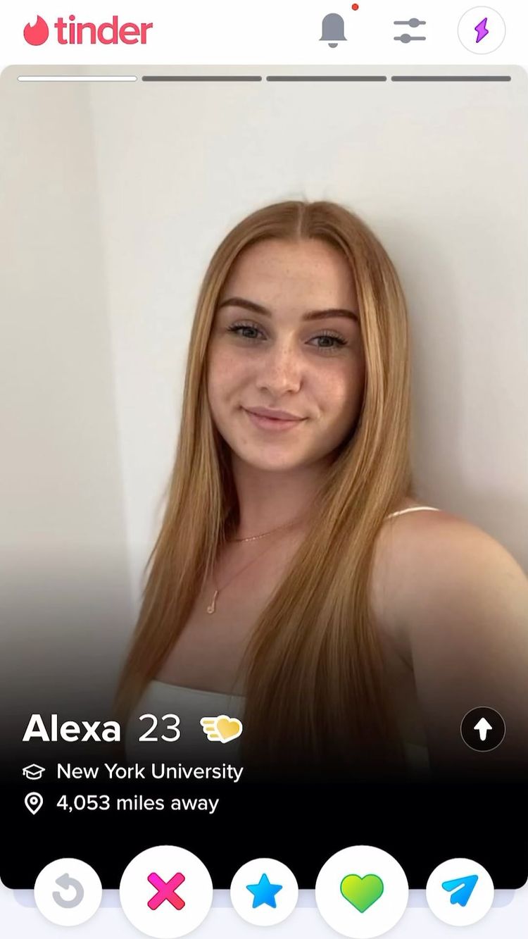 A Tinder profile screenshot. The image shows a young woman named Alexa with long blonde hair and fair skin. The profile includes her age (23), her university (New York University), and her distance from the viewer (4,053 miles away).
