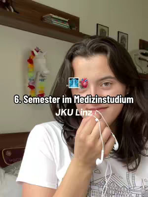 A young woman with dark hair is in a selfie-style shot. She's holding white earbuds near her face, with text overlays indicating the video's topic. The background shows a room with a shelf holding items. The overall composition is well-lit and emphasizes the subject.