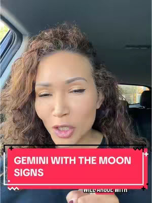 A woman with long, curly hair is seated inside a car, facing forward. A red banner with white text overlays the bottom portion of the image. The background suggests an outdoor setting.
