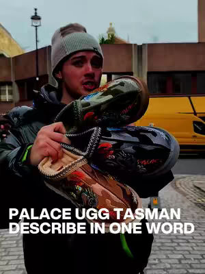 A young man holds three pairs of Palace UGG Tasman shoes against an urban background. He is wearing a gray beanie, a black jacket, and has a neutral expression. The shoes are the primary focus, with a yellow van visible in the background.