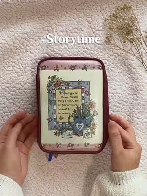 The cover image shows a pair of hands holding a Bible case. The case is rectangular with rounded edges, cream-colored with decorative floral patterns. A hashtag appears above the case, and a small sprig of dried leaves is visible in the upper right corner. The background is a soft, textured surface in a light color.