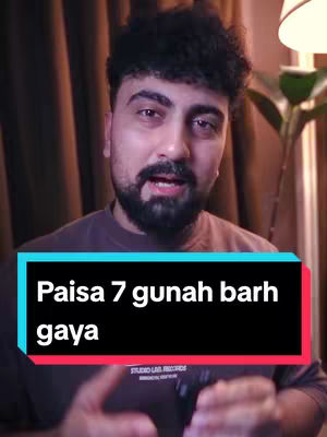 A man with a beard looks directly at the camera, with a text overlay on the bottom which reads, "Paisa 7 gunah barh gaya". The background is blurred, warm-toned.