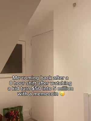 The image shows a room interior. The ceiling slopes upward from left to right, with a light fixture on the right side. The walls are white. In the lower left corner, there is a glimpse of a green and white bag, likely a grocery bag. The main text overlay is in the image.