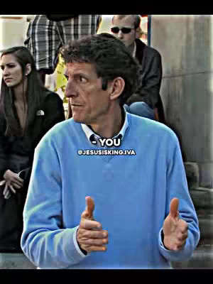 A medium shot features a man with short, graying hair and a light blue sweater, gesturing with both hands in a thumbs-up position. He is positioned in front of a blurred background of people and architecture. Overlayed text includes a call-to-action and a username.