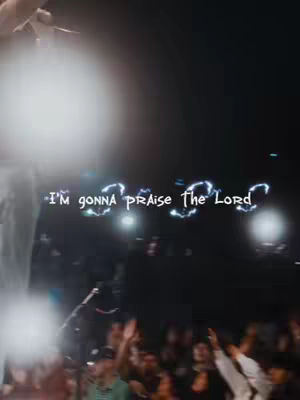 The image captures a live performance or event with an obscured figure raising their hand in the foreground. The background shows a crowd of people with illuminated lights. The overlaid hook text reads, "I'm gonna praise The Lord" in stylized font.