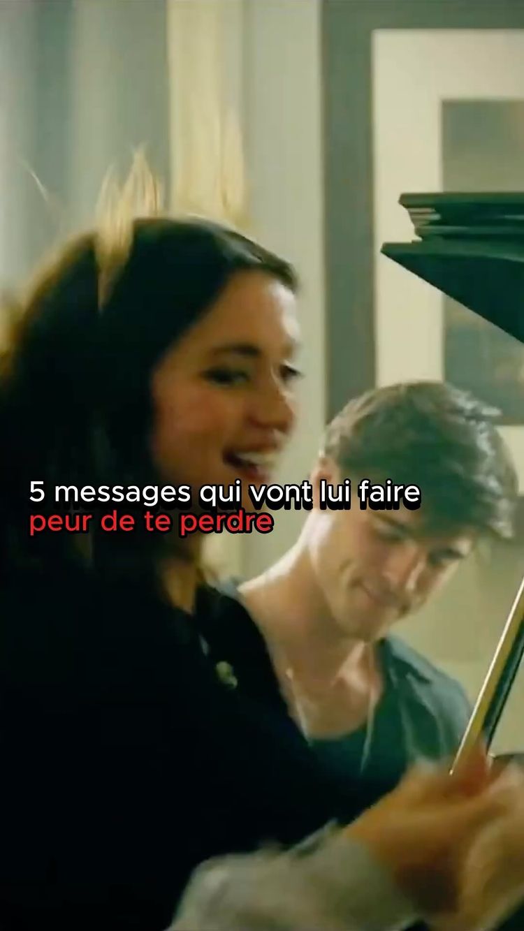 The cover image shows a woman and a man in an indoor setting. The woman, positioned in the foreground, is smiling and looking towards the left. Behind her, a man is slightly blurred, angled forward. The background appears to be a room with furniture, and there's overlaid text. The lighting seems soft. 