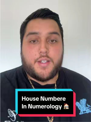 A man with a full beard and dark hair is centered in the frame, set against a subtle, blurred background. He wears a black shirt with a gold chain. Overlaying his lower torso is a stylized text box in shades of blue, red and light blue. The text reads "House Numbere In Numerology" with a small house icon next to the word "Numerology".